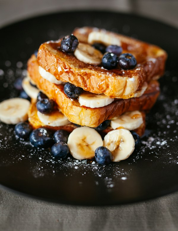 Stack of French toast with banana and berries
