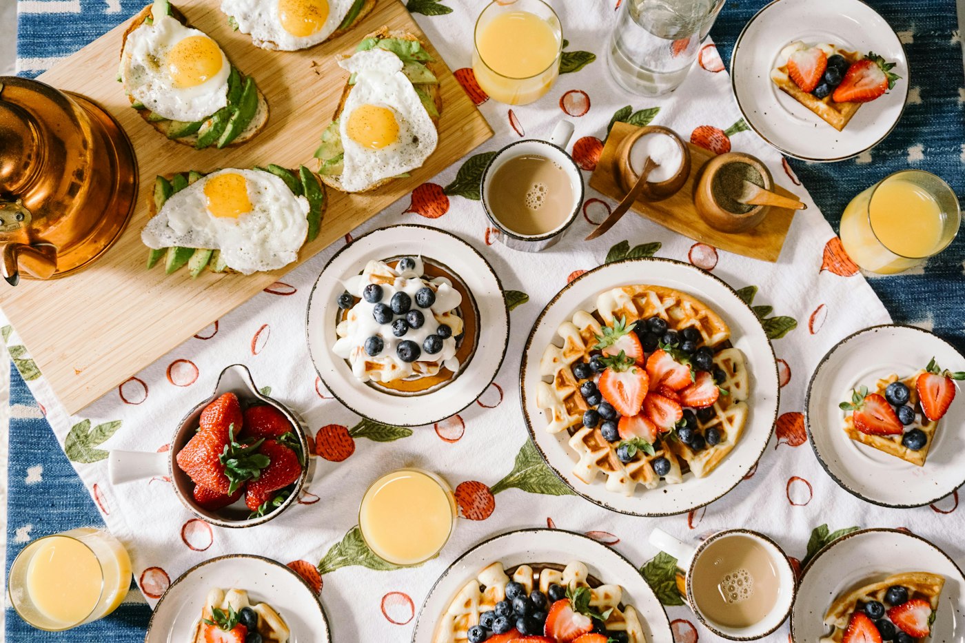 Breakfast table with eggs, waffles, fruit and coffee
