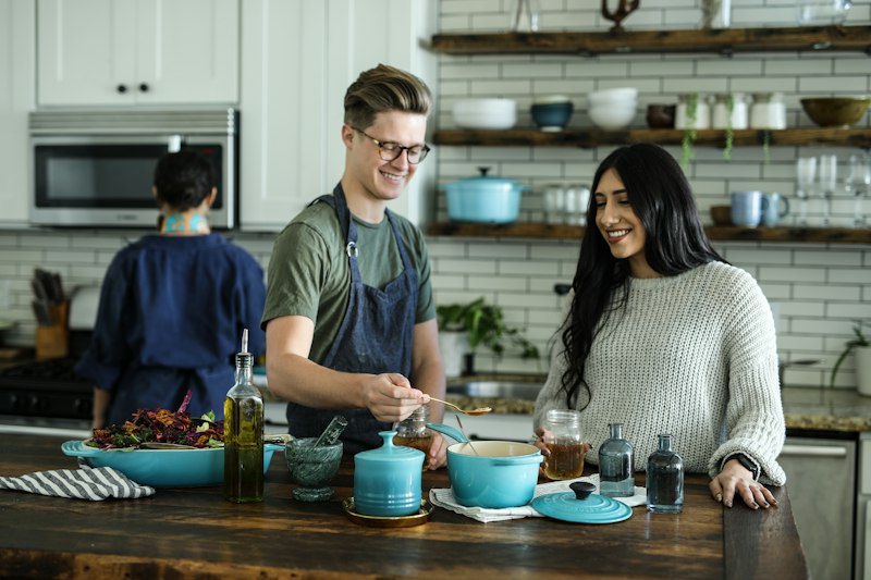 Friends cooking breakfast together in a home kitchen