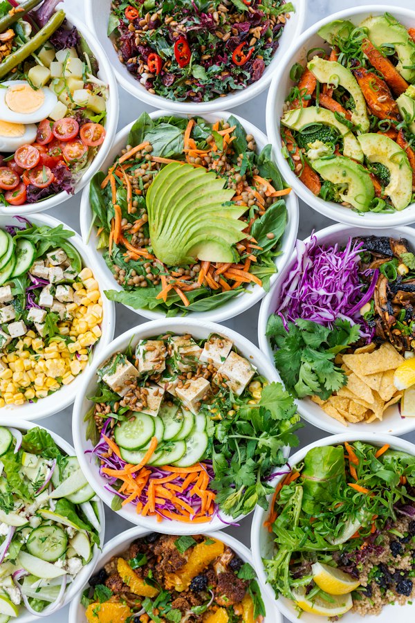 Colourful bowls of fresh salad, avocado and vegetables